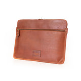 The Vintage Leather Sydney Leather Laptop Sleeve Signature features brown leather, a front zippered pocket, and a small embossed logo on the lower front, shown against a white background.