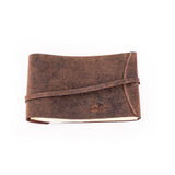 A closed Leather Photo Book Memo by Vintage Leather Sydney with visible stitching and a wraparound strap, shown lying on a white background.