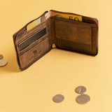 The Discover the Ultimate Mens Zipper Wallet - Urban by Vintage Leather Sydney sits open on a yellow surface with bills and cards inside, surrounded by coins. This brown full-grain leather wallet features RFID-blocking technology for security.
