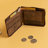 The Vintage Leather Sydney Discover the Ultimate Mens Zipper Wallet - Urban, crafted from full-grain leather, sits open on a yellow surface with visible cards, cash, and scattered coins nearby.