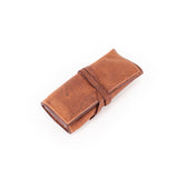 The Leather Artist Roll Zip by Vintage Leather Sydney is a brown leather roll-up pouch featuring visible stitching and a wrap-around leather tie, shown on a white background.
