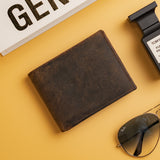 The Hugo Mens Leather Bifold Wallet by Vintage Leather Sydney, featuring RFID protection, sits on a yellow surface with a book, black Tom Ford perfume bottle, and aviator sunglasses—a classic men’s wallet setup.