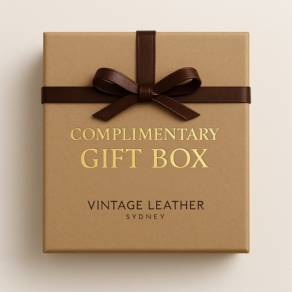 A brown gift box with a dark brown ribbon and gold text reading Free Gift Box RRP $99 (100% off)—your free gift. Below, black text displays Vintage Leather Sydney. Set against a light beige background. Powered by the BOGOS app.