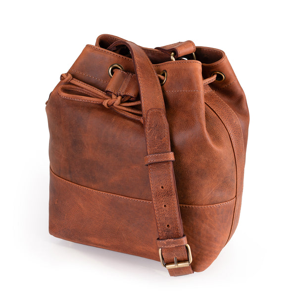 The Rosa Leather Crossbody Bag by Vintage Leather Sydney is shown on a white background, featuring brown leather with a drawstring closure, adjustable shoulder strap, and brass hardware.
