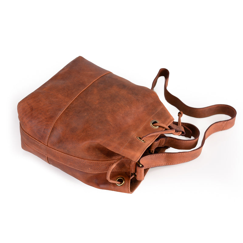 The Rosa Leather Crossbody Bag by Vintage Leather Sydney, featuring a spacious main compartment and adjustable strap, is displayed on its side against a white background.