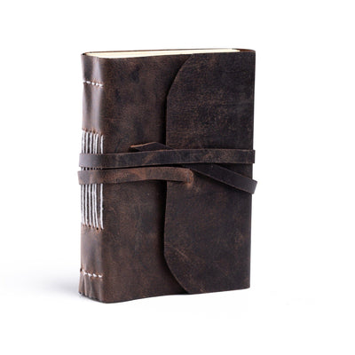 The Indigo Journal Leather by Vintage Leather features brown buffalo leather, a wraparound strap, and white spine stitching. Stands upright against a plain white background. Personalisation available for a unique touch.